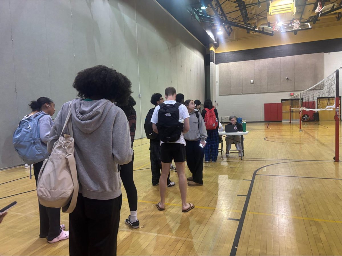 Students line up in the gym to submit outside guest forms for prom.