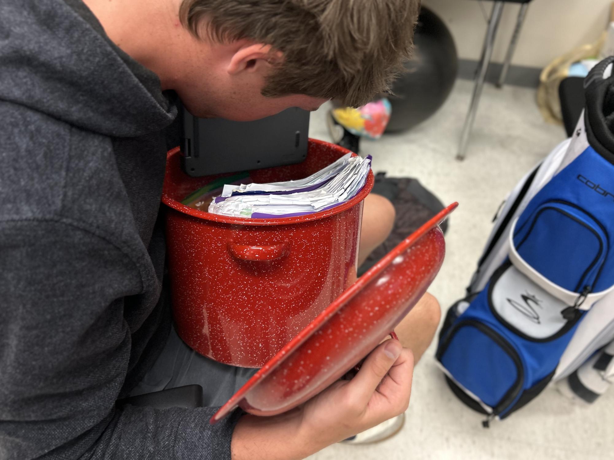 Senior and SGA President Liam Recklaus peers into his cooking pot, searching for his papers.